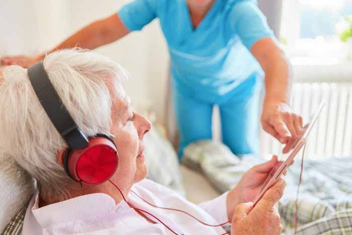 Services multimédias à l'hôpital - personne agee avec soignant tablette casque - services multimedias
